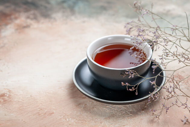 壁板侧视一杯茶一杯茶放在树枝旁的红茶碟上潘趣分支