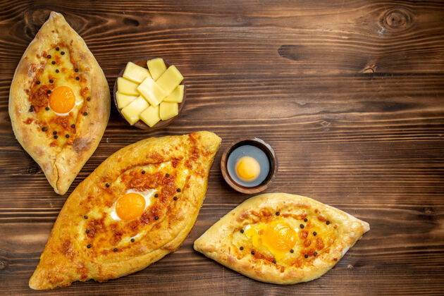 小面包顶视图烤鸡蛋面包从棕色木制桌子上烤箱新鲜面包面团面包包早餐面包奶酪生的