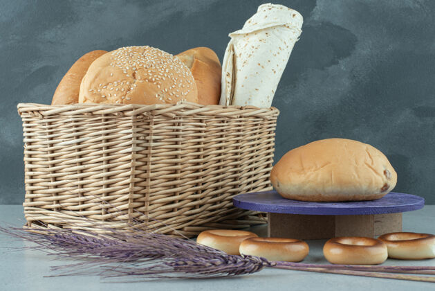 面包篮子里的各种面包和石头表面的饼干谷类食品混凝土饼干