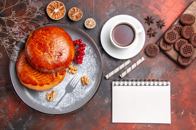 早餐俯瞰美味的馅饼配上一杯茶放在深色的桌子上甜甜的馅饼糕点蛋糕水果烘焙食品食物