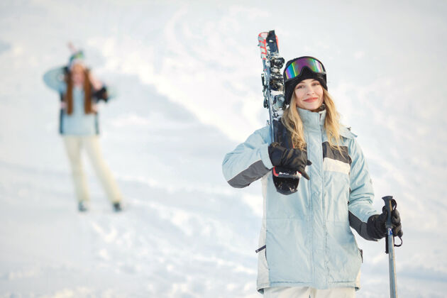 红色在雪山的背景下 滑雪者在山坡上摆姿势运动女人冷