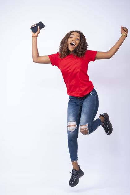 女人一个快乐的非洲女性在兴奋中跳跃的垂直镜头表情喜悦非洲