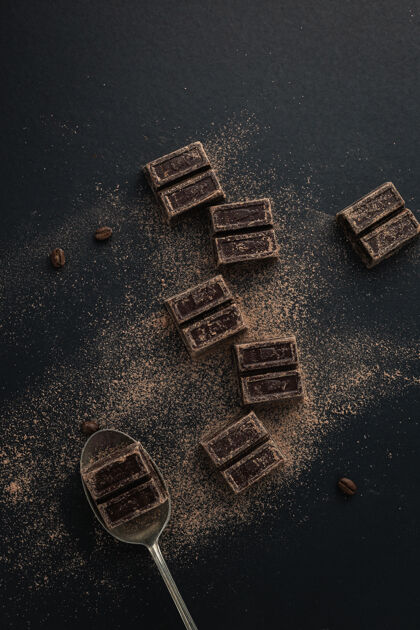 棕色咖啡豆和撒有可可粉的黑巧克力的俯视图甜点咖啡粉末