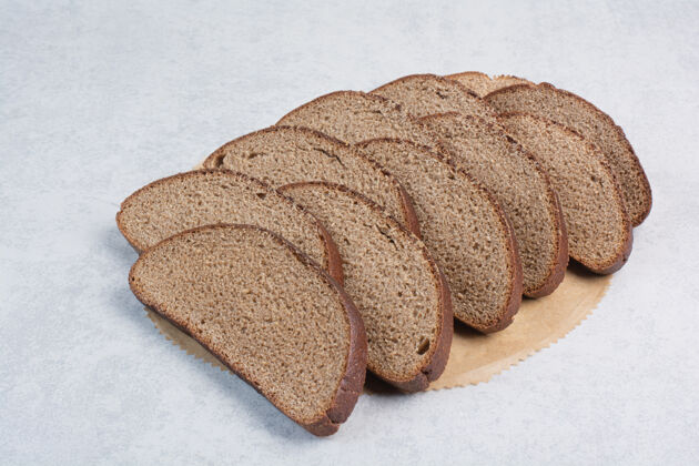 面包皮黑面包片在纸上种子切片谷类