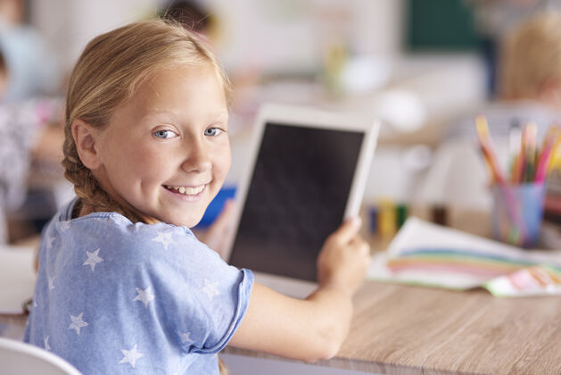 学习女孩在学校使用数字平板电脑书桌学生拿着
