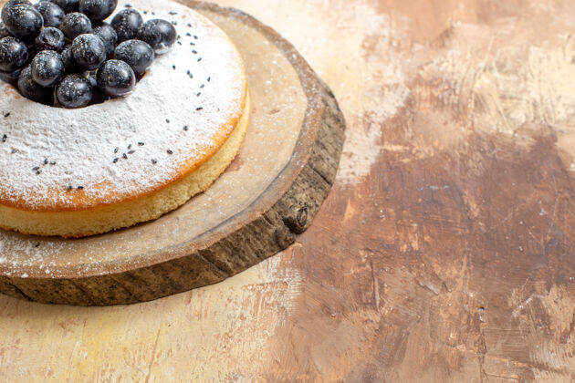 谷物侧面特写蛋糕木板配黑葡萄和糖粉蛋糕蛋糕粉末质地
