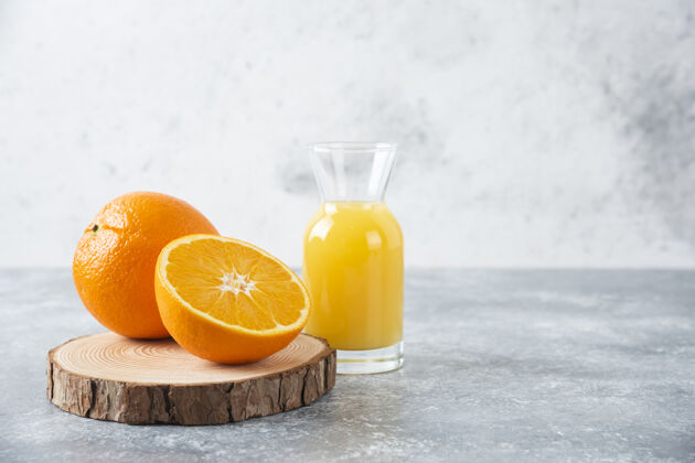 异国情调在木板上放一个装有橙子切片的果汁的玻璃罐新鲜成熟液体
