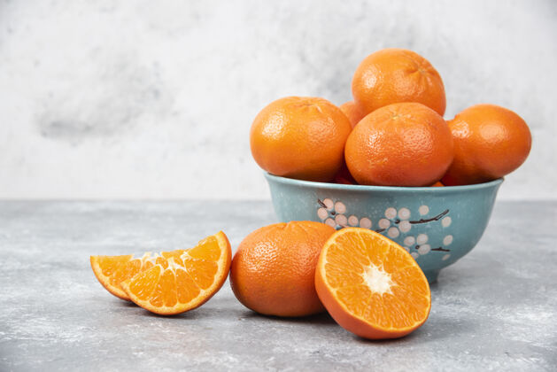 分割把新鲜多汁的橙子全切在一个放在石桌上的碗里食品片切