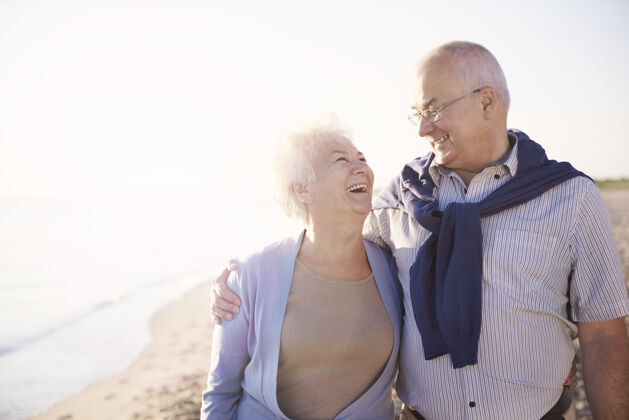 团聚老年夫妇在沙滩 退休和暑假的概念快乐欢笑假期