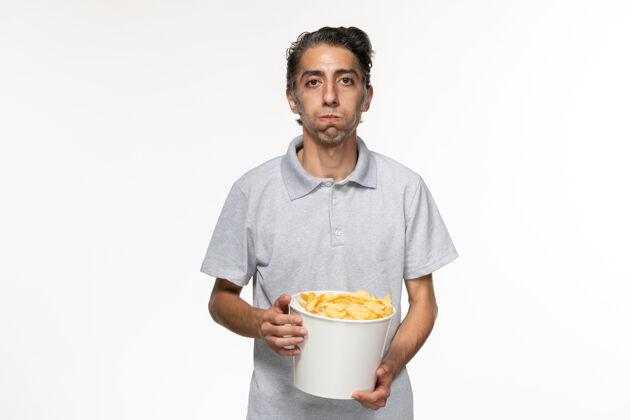 电影院正面图年轻男性在白色表面吃薯片电影土豆早餐食品