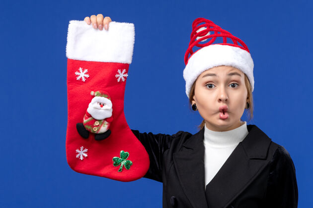 女人正面图年轻女子拿着圣诞袜在蓝色墙壁上女人过年前面欢乐股票