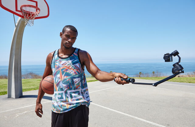自拍篮球运动员在海边与自拍相机球场姿势Instagram