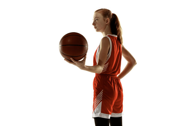 球员年轻的女篮球运动员在白墙上摆姿势训练健身房运动
