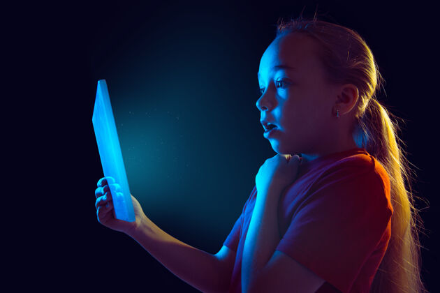 商业霓虹灯下拿着平板电脑的小女孩夜晚快乐屏幕