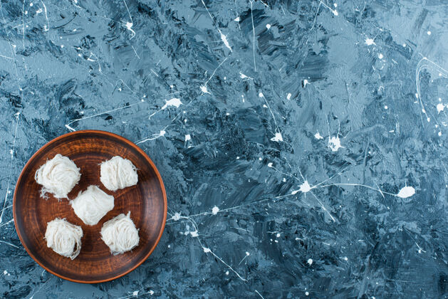 美味传统的土耳其棉花糖放在木制盘子上 蓝色背景传统美味糖