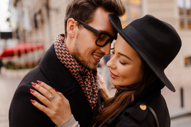 伦敦浪漫的情侣面对面的拥抱和微笑温暖舒适的色彩 冬天的心情帅哥和优雅的黑发女人漫步在城市里肖像休闲性感