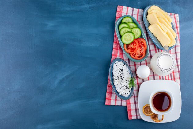蔬菜美味的早餐 茶 牛奶和奶酪在蓝色的表面小吃美味食物