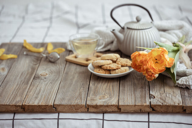 花一杯茶 一個茶壺 餅干和一束郁金香早上茶壺早餐