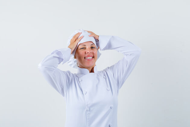 手一位身穿白色制服的女厨师手把手放在头上 看上去很乐观女士时尚模型