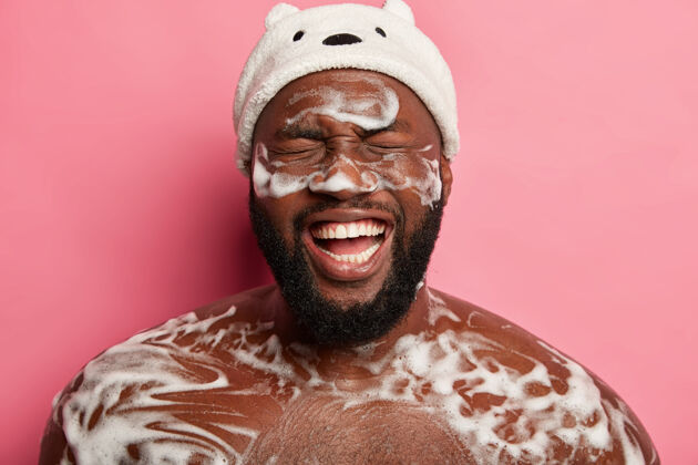 男性水疗 卫生和放松的概念赤裸的黑色未刮胡子的男子洗澡泡沫 在浴室里有乐趣 洗身体 从快乐中微笑 快乐地开始一天清洁放松口腔