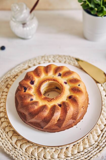 烘焙白色桌子上的环形蛋糕的垂直镜头圆形鲜花自制