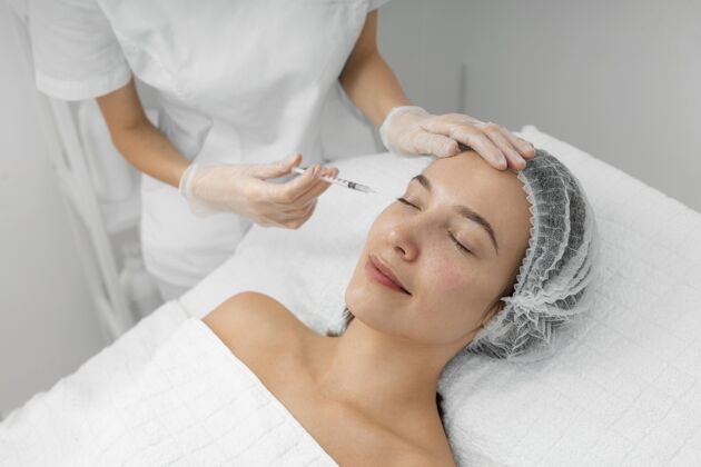 美容护理美容师在美发厅为女性客户注射填充物治疗女人注射