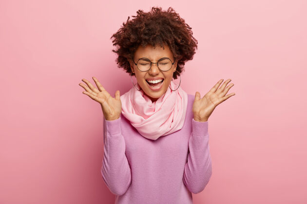 年轻开朗的女人 卷发 欢笑 侧着手掌 戴着丝巾和紫色马球衫快乐人肖像