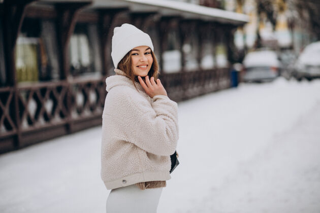 快乐街外穿冬装的年轻女子降雪积极美丽