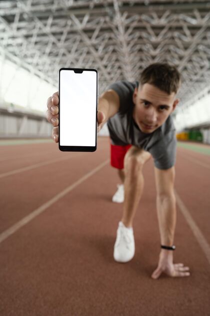 男子全速运动员手持智能手机活跃运动垂直