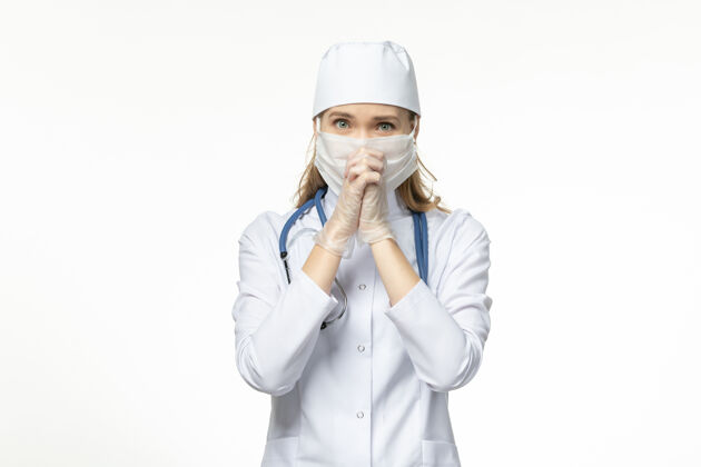 女性前视图身穿白色医疗服 戴着白色口罩的女医生 以防白墙上的冠状病毒感染人微笑肖像