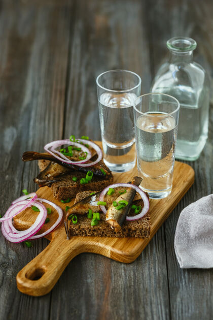 补品伏特加配鱼和面包烤面包放在木桌上纯食物小吃
