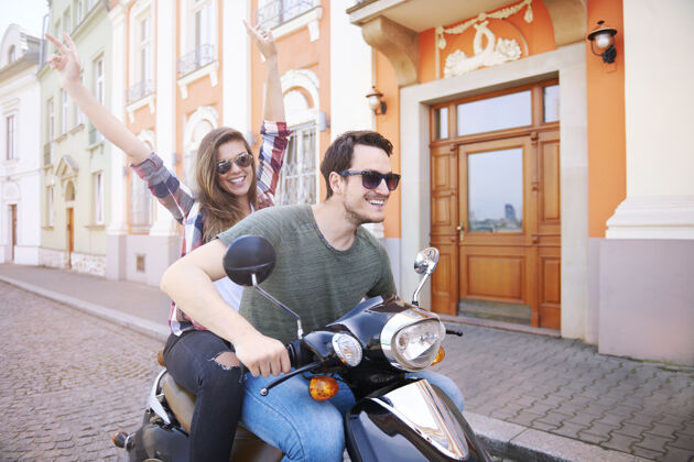 街道风格一对夫妇在城里骑摩托车夏天情侣女人