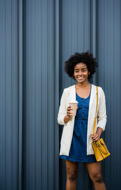 女性一张非洲裔女商人站在街上喝咖啡的照片商业和城市概念女人咖啡外卖肖像