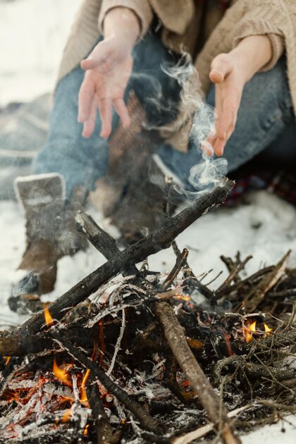 男人冬天在篝火旁取暖的人人表情季节