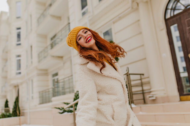 欧洲在寒冷的日子里 戴着帽子的长发女孩微笑着在冬天 姜黄色的年轻女子在户外散步冷杉云杉兴奋