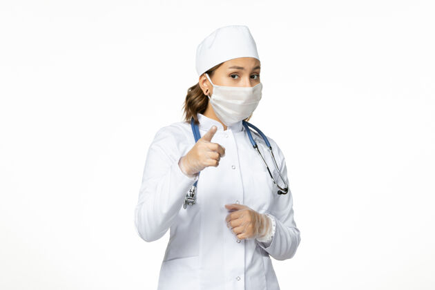 大流行正面图年轻女医生带着无菌口罩因白色表面有冠状病毒女性疾病冠状病毒