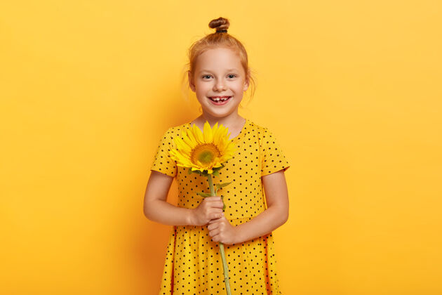 女孩高兴的小红发女孩和黄裙向日葵合影欢呼孩子人
