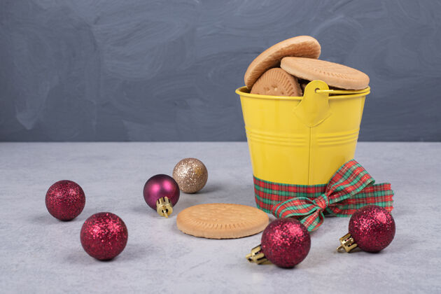 糕点饼干桶装饰丝带和圣诞球在白色的桌子上高品质的照片面包房美味舞会