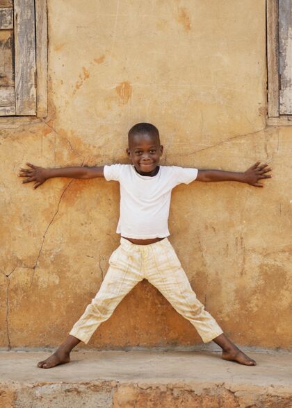 农村全镜头的小孩在墙上摆姿势孩子民族非洲