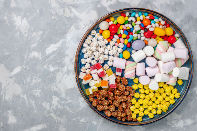 容器顶视图糖果组成不同颜色的糖果与棉花糖在白色办公桌上糖果邦邦甜的知己容器生的糖果
