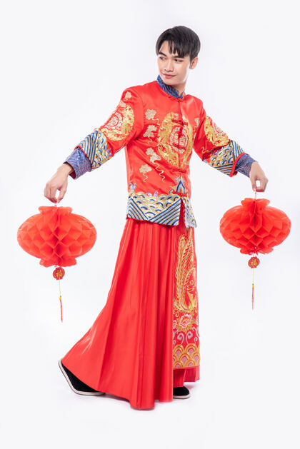 中国新年穿旗袍西服的男人在过年的时候到他店里装饰红灯中国民族成人旗袍