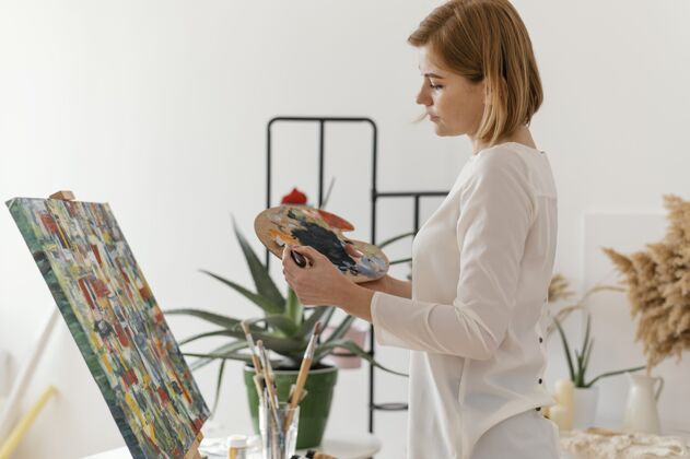 女性美丽的女人在画布上用丙烯酸树脂绘画艺术室内绘画