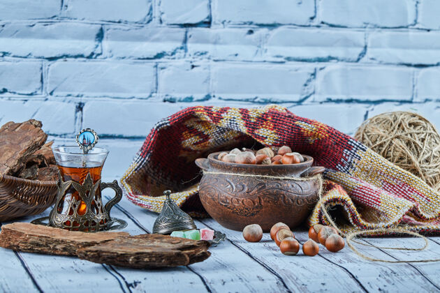 玻璃一碗榛子放在蓝色的木桌上 上面有雕刻的地毯传统地毯阿塞拜疆