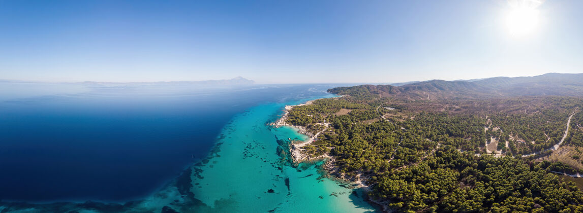 海滩爱琴海海岸的广角镜头 蓝色透明的海水 周围绿意盎然 从无人机上俯瞰帕莫拉马 希腊海岸海岸线海湾