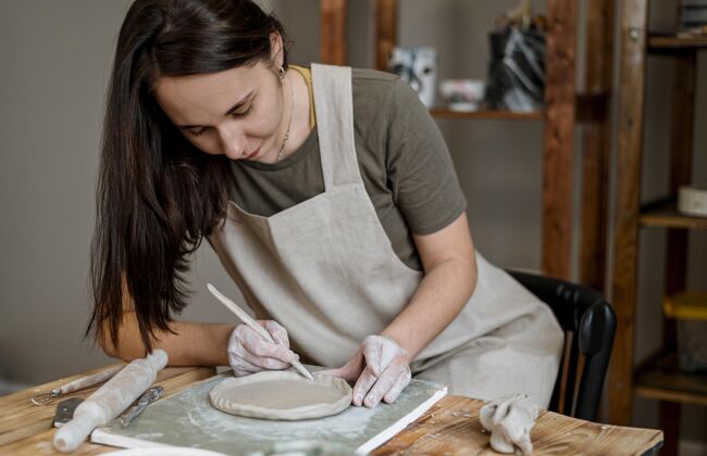 工艺有创意的女人在她的工作室里做一个陶罐工作场所陶瓷专业