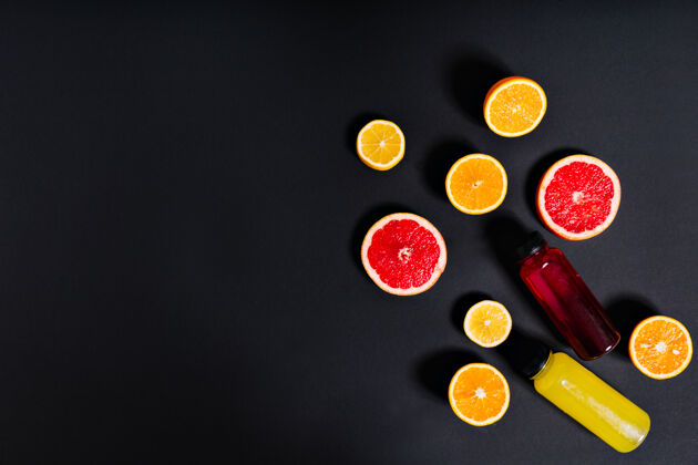 多汁鲜榨的柑橘汁放在瓶子里 四周是一半的橙子 柠檬和葡萄柚柠檬装饰甜味