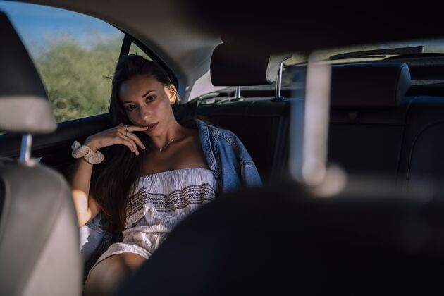 背部一个美丽的年轻白人女性在一个领域的汽车后座摆姿势的水平镜头车辆白人女孩