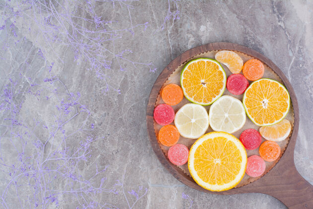 美味在砧板上放几片橘子 橘子和糖果橘子柠檬五颜六色