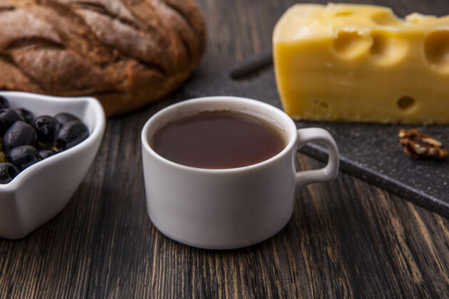 饮料侧视图：桌上放着橄榄和黑面包 桌上放着一杯加马斯坦奶酪的茶橄榄红茶杯子
