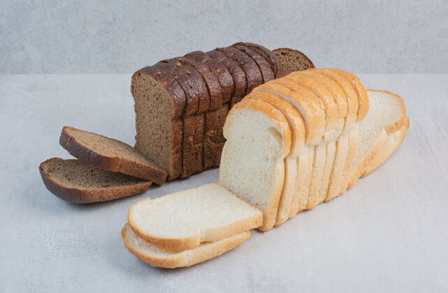 糕点新鲜的白色和棕色面包片放在大理石背景上小吃面包面包房